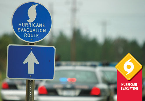 Police vehicles behind a Hurricane Evacuation Route sign
