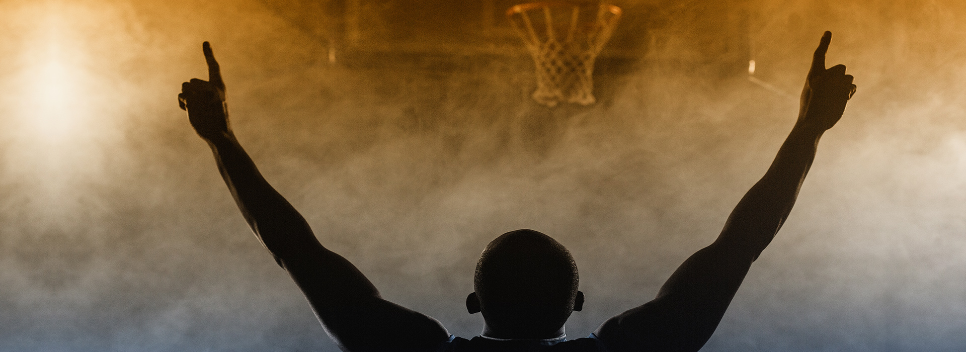 A basketball player with arms up in celebration