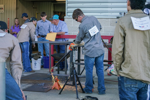 One welder works as others look on.