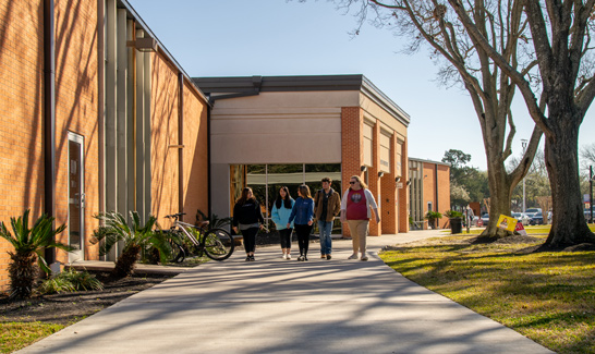 Four students walk outside the Lee College Student Center