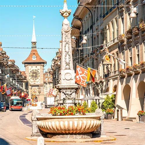A city scene from Switzerland, with clocks and buildings.
